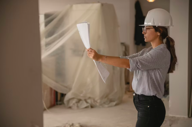 Woman Wearing a Hardhat in a Commercial Office Building Under Construction